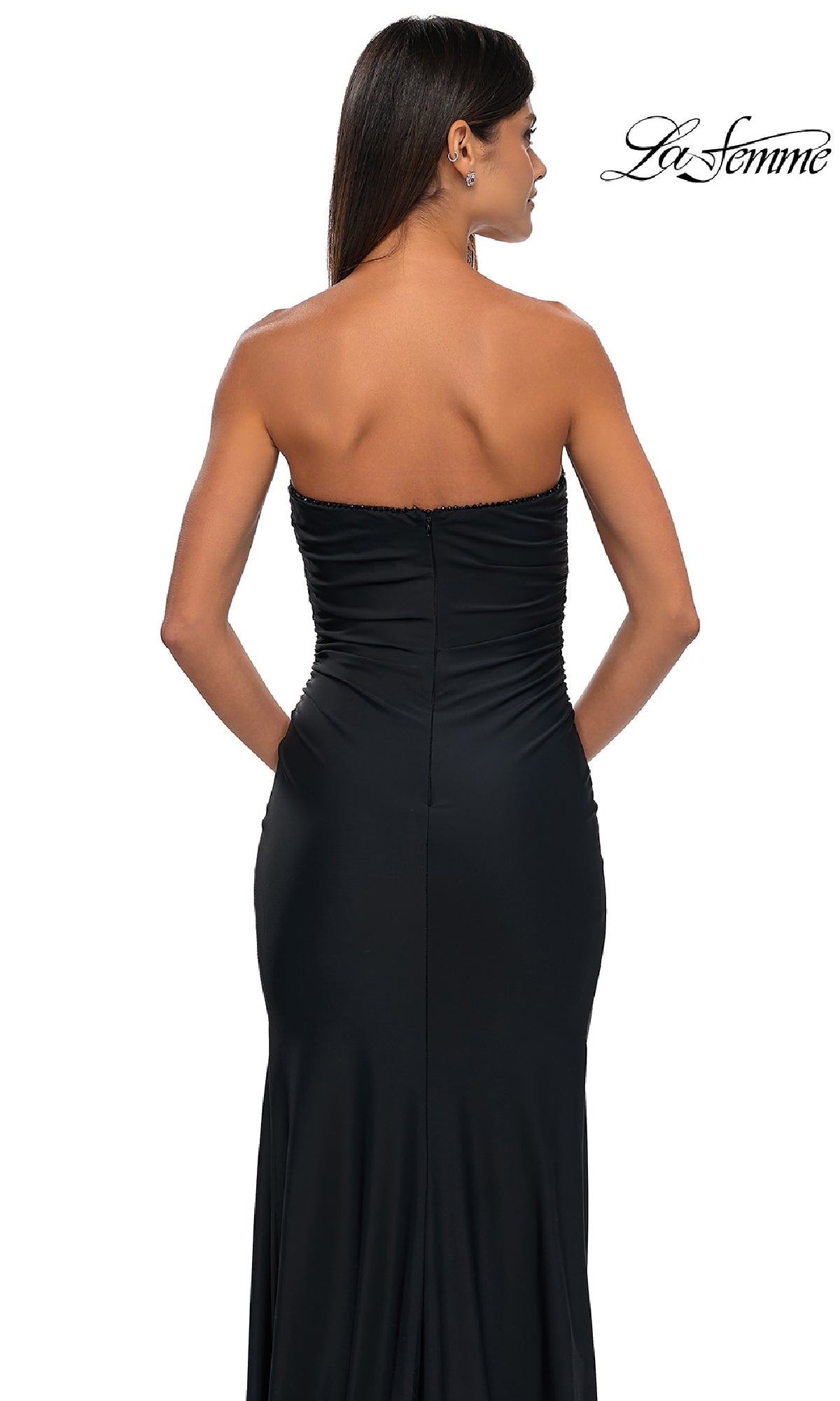 Model wears the Simple Strapless Long Prom Dress, La Femme 32360, facing away to showcase its elegant back details against a white backdrop.